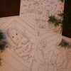 Photo of advent card illustrations. Illustrations include baby Jesus in the manger, the sky full of angels, and the three wise men.