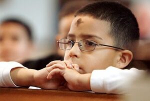 photo of a young boy at church, with an ash cross on his forehead